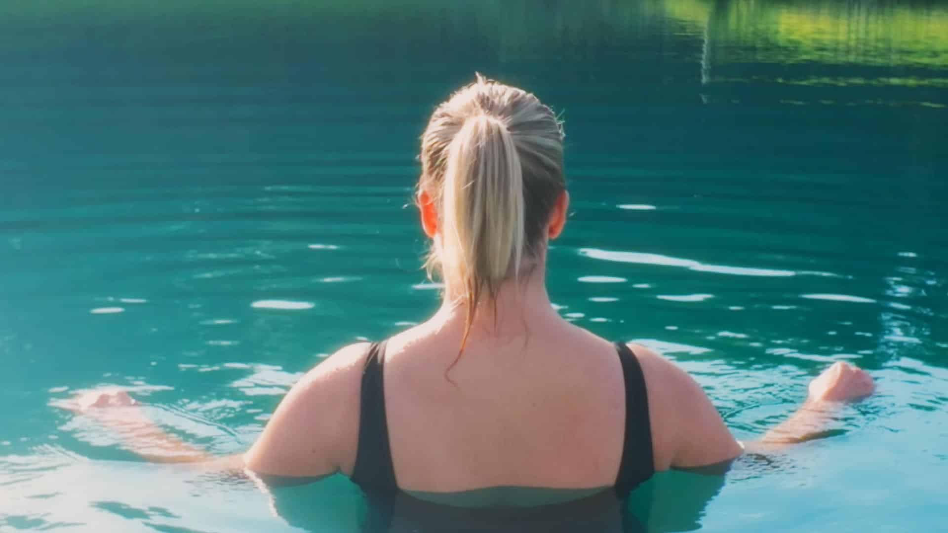 A guest taking a calm dip in the clear waters of Crystal Lake
